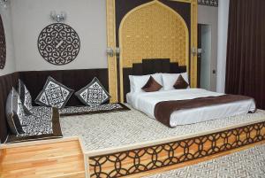 a bedroom with a large bed with a gold and white bed frame at Ramada by Wyndham Turkistan in T&uuml;rkistan