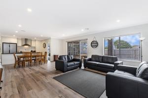a living room with a couch and a dining room at Park View in Port Fairy
