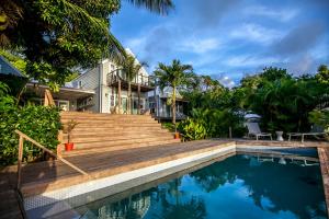 a house with a swimming pool in front of a house at Red Coconut Self-Catering in Mahe