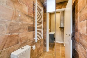 uma casa de banho com um WC e uma parede em azulejo em Els Templers em Castelló d'Empúries