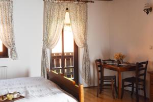 a bedroom with a bed, table, lamp and a window at Turistična kmetija Šeruga in Novo Mesto