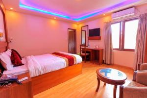 ein Schlafzimmer mit einem Bett, einem Tisch und einem Sofa in der Unterkunft Everland Kathmandu Hotel in Kathmandu