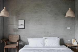 um quarto com uma cama branca e duas luzes pendentes em Seaside Snooze em Xiaoliuqiu