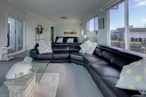 a living room with a black leather couch at Sandy Cove in Port Fairy