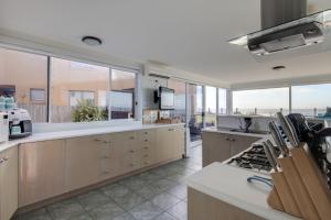 a large kitchen with wooden cabinets and a large window at Sandy Cove in Port Fairy