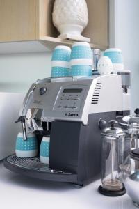 une cafetière assise sur un comptoir avec des tasses bleues dans l'établissement Sandy Cove, à Port Fairy