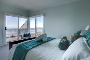 a bedroom with a bed with a laptop on it at Sandy Cove in Port Fairy