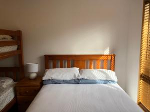 a bed with a wooden headboard and white pillows at Seahorse Coastal Villas in Peterborough