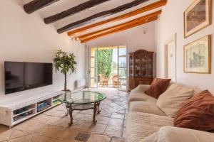 a living room with a couch and a tv at Lidia Rural House in San Martín Sarroca