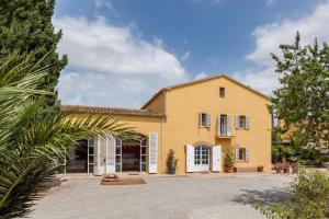 Una gran casa amarilla con una gran entrada en Lidia Rural House, en Sant Martí Sarroca