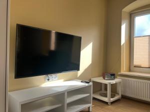 a living room with a large television on a wall at Apartament MRĄGOWIA in Mrągowo