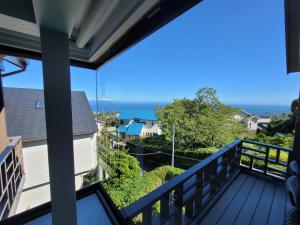 a balcony with a view of the ocean at オザッキー大室高原９丁目 in Futo