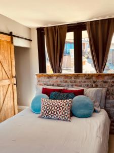 ein Schlafzimmer mit einem Bett mit Kissen und einem Fenster in der Unterkunft Finca Cazosa in Valle de Guadalupe