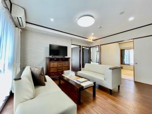 a living room with two white couches and a tv at ホテル天使館 久茂地 -Tenshi-Kan- in Naha +230 photos