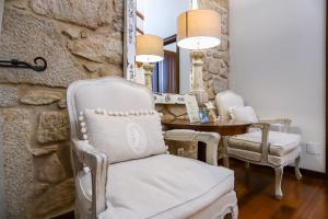 a room with a white chair and a table at Torre do Rio in Caldas de Reis