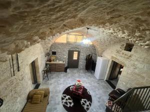 a living room with a large stone wall at Qandeel - Dar Botto in Bethlehem