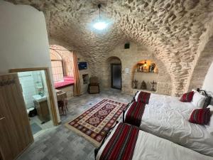 1 dormitorio con 1 cama grande en una habitación de piedra en Qandeel - Dar Botto en Bethlehem