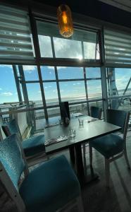 a table and chairs in a room with a large window at Sea view apartment at the beach! in Llanelli