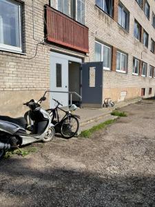 uma moto e uma scooter estacionadas ao lado de um edifício em Уютная квартира в Маарду em Maardu