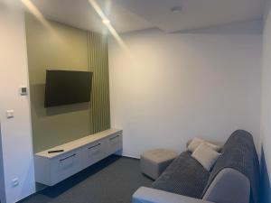 a living room with a couch and a flat screen tv at Apartman Juraj in Liptovský Mikuláš