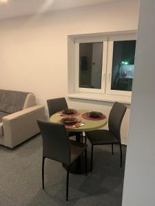 a living room with a table and chairs and a couch at Apartman Juraj in Liptovský Mikuláš