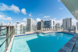a swimming pool on the roof of a building at Studio Home Service em Boa Viagem - Limpeza Lavanderia Internet in Recife