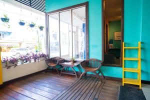 a porch with two chairs and a table and a window at Sans Hotel Zam-Zam Syariah Palangkaraya in Palangkaraya