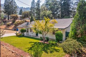 ein kleines weißes Haus mit einem Hof in der Unterkunft Acorn House - Charming house in green heaven with pool table with lovely backyard in Oakhurst