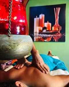 un hombre recibiendo un masaje de espalda en una cama en Raj Mahal Inn, en Wadduwa