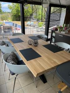 une table en bois avec des verres assis au-dessus dans l'établissement B&B Le calme sur les hauteurs de Spa, à Tiège