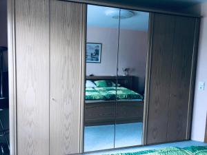 a reflection of a bedroom with a bed in a mirror at Veronikas Wohnung mit Garten in Wegscheid
