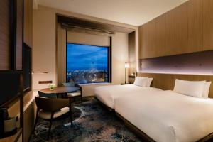 a hotel room with a large bed and a window at Hilton Hiroshima in Hiroshima