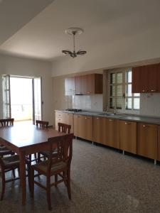 cocina con mesa de madera y comedor en Le Palme di Riace 2, en Riace Marina