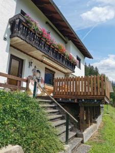 a house with a balcony with flowers on it at Ferienwohnung im Nationalpark Gesäuse in Hieflau
