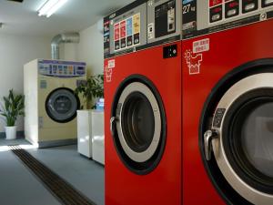 a couple of washing machines in a laundry room at Denpaku Amami Hotel in Amami