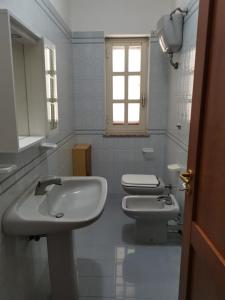 ein weißes Badezimmer mit 2 Waschbecken und einem WC in der Unterkunft Le Palme di Riace 2 in Riace Marina