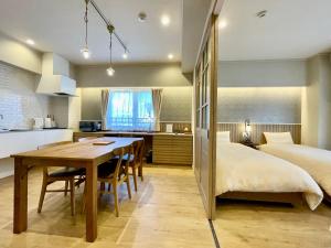 那霸的住宿－ホテル天使館 久茂地 -Tenshi-Kan-，厨房以及带桌子和床的卧室。