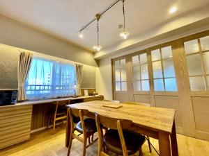 a dining room with a wooden table and chairs at ホテル天使館 久茂地 -Tenshi-Kan- in Naha