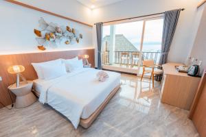 Sea La Vie Resort Nusa Penida في نوسا بينيدا: غرفة نوم بسرير كبير ونافذة كبيرة