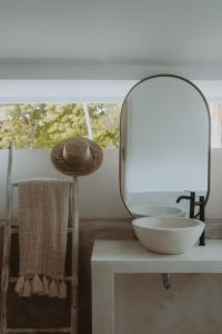 baño con espejo y lavamanos en una mesa en La Isla Bonita Gili Air, en Gili Air