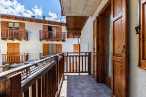 Un balcón de una casa con barandillas de madera en Appartamento Lucia, en Baselga di Pinè