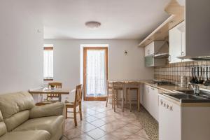 cocina y sala de estar con sofá y mesa en Appartamento Lucia, en Baselga di Pinè