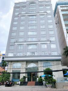 duży budynek z napisem z przodu w obiekcie Acnos Grand Hotel w Ho Chi Minh