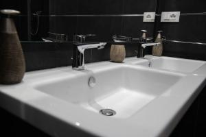 lavabo blanco con 2 grifos en el baño en Vatican2you, en Roma