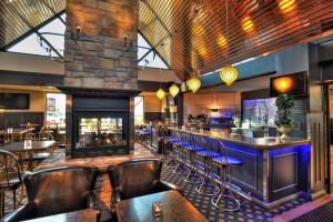 a bar with leather chairs and a fireplace in a restaurant at L'Escale Hôtel Suites in Val-dʼOr