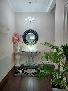 Cette chambre comprend un miroir, une table et des plantes. dans l'établissement Gabriel Guesthouse, à Rhyl