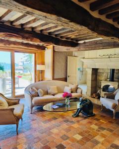 a living room with a couch and a fireplace at Le Manoir des Impressionnistes - Bord de Mer in Honfleur