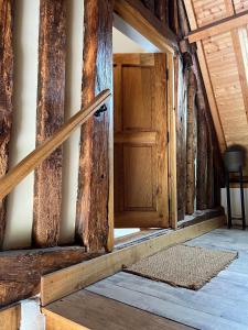 uma porta de madeira aberta num quarto com um tapete em Le Domaine des Bois em Blangy-le-Château