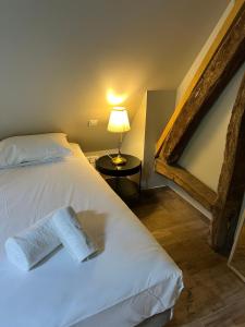 a bedroom with a white bed and a lamp on a table at Le Domaine des Bois in Blangy-le-Château