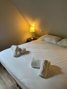 a bedroom with a bed with towels on it at Le Domaine des Bois in Blangy-le-Château